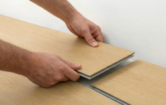 Instalador encastrando tablas de piso SPC vinílico con sistema click